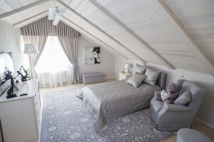 lit avec couvre-lit gris dans la chambre