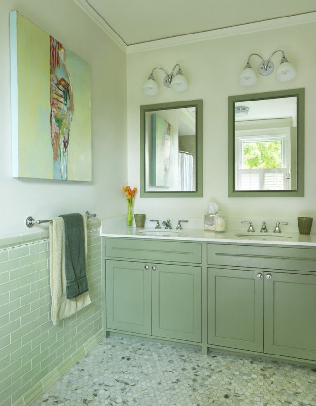 Salle de bain décorée dans différentes nuances de couleur menthe.  Une peinture abstraite sur le mur avec un fond jaune doux ajoute de la chaleur à l'intérieur 