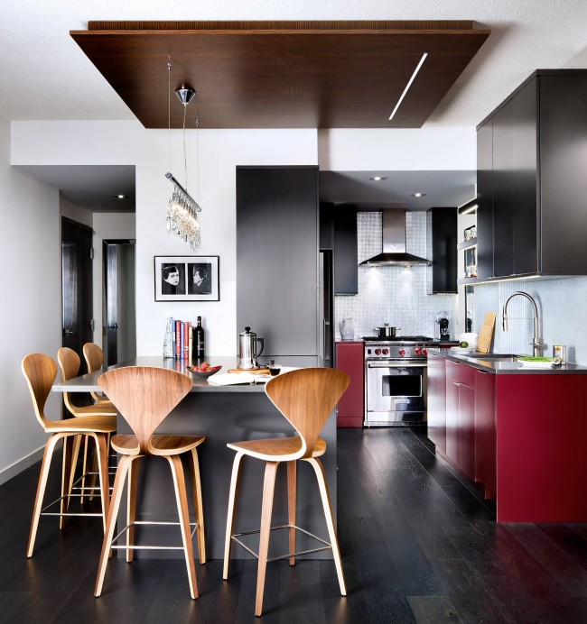Cuisine studio confortable dans un petit appartement.  Les accents rouges audacieux et brillants sur les éléments de l'ensemble de cuisine semblent très organiques dans l'ensemble de l'intérieur