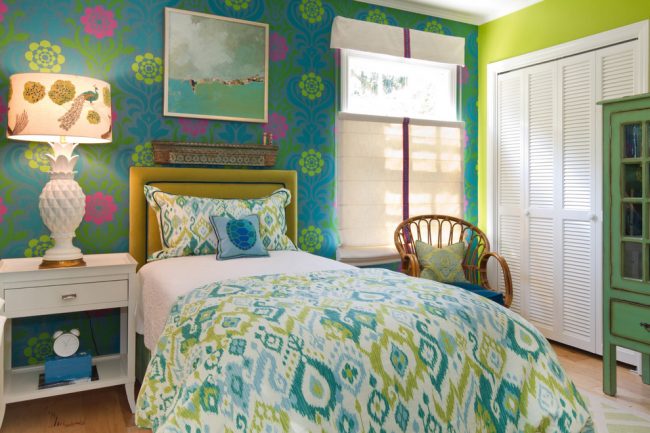 Le mur à la tête du lit est mis en valeur avec du papier peint textile foncé