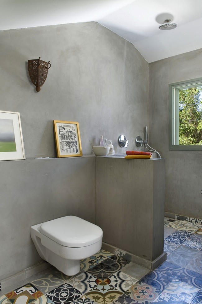 Une combinaison organique de carreaux ornementaux au sol avec des murs en béton dans une salle de bain combinée d'une maison privée