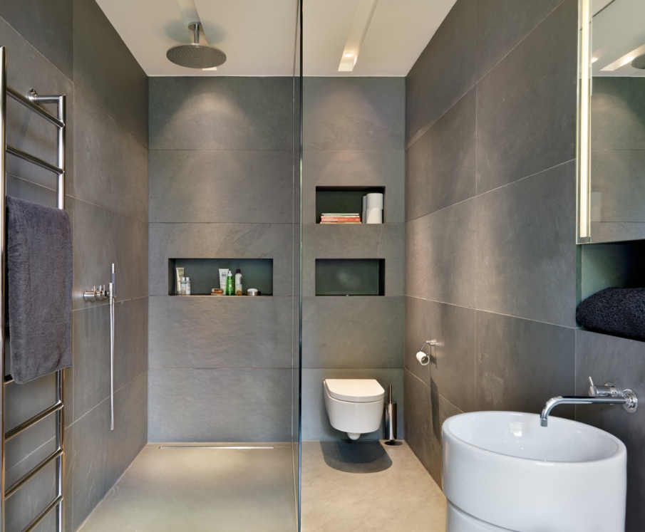 Toilettes suspendues modernes dans une salle de bain combinée dans des tons gris