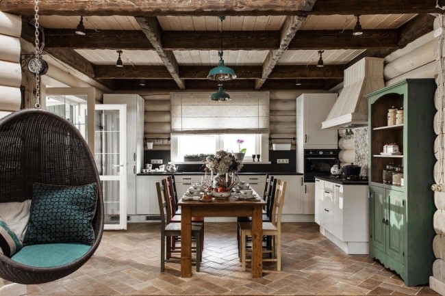 La cuisine faite d'une maison en rondins beige clair est combinée de manière intéressante avec des accents turquoise dans les meubles