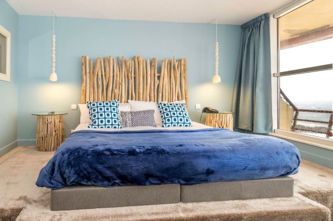Pour une chambre à thème marin, des rideaux bleus sur toute la longueur de la fenêtre conviennent