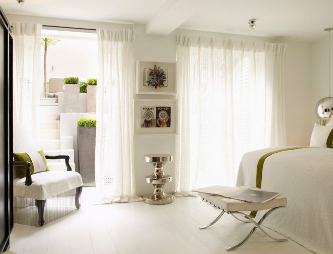 Les rideaux ajourés blancs classiques sont magnifiques dans une chambre lumineuse de style méditerranéen