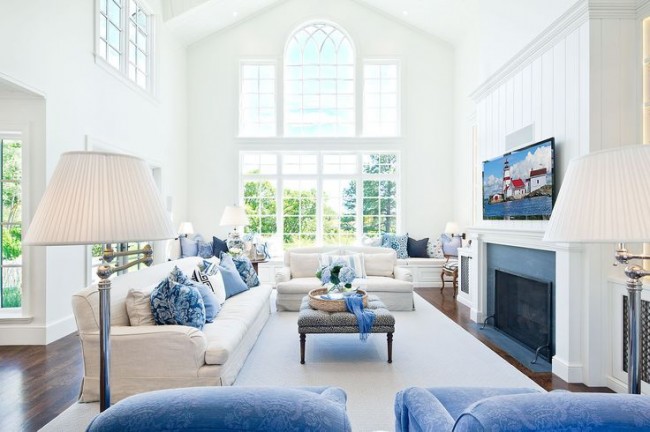 Les éléments bleus à l'intérieur du salon semblent beaucoup plus chauds en combinaison avec des meubles moelleux et un lampadaire crémeux.