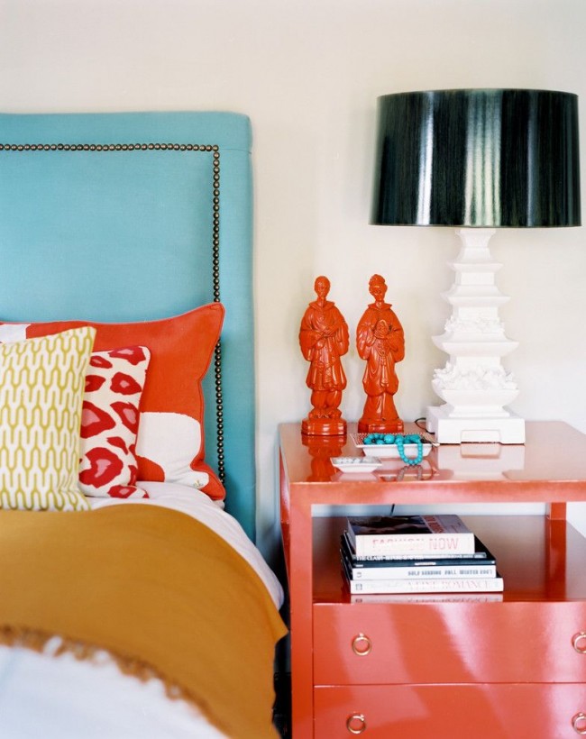 Chambre à coucher élégante et confortable combinant des meubles bleus et des éléments corail-pêche 