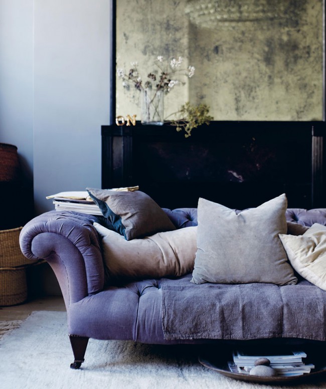 Le revêtement du canapé en velours lilas avec du bois foncé crée un duo luxueux