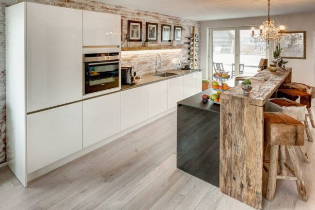 Le comptoir de bar en bois s'intègre parfaitement à l'intérieur de la cuisine-salle à manger ouverte