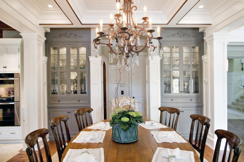 La salle à manger de style classique est séparée de la cuisine par de beaux piliers sur les côtés