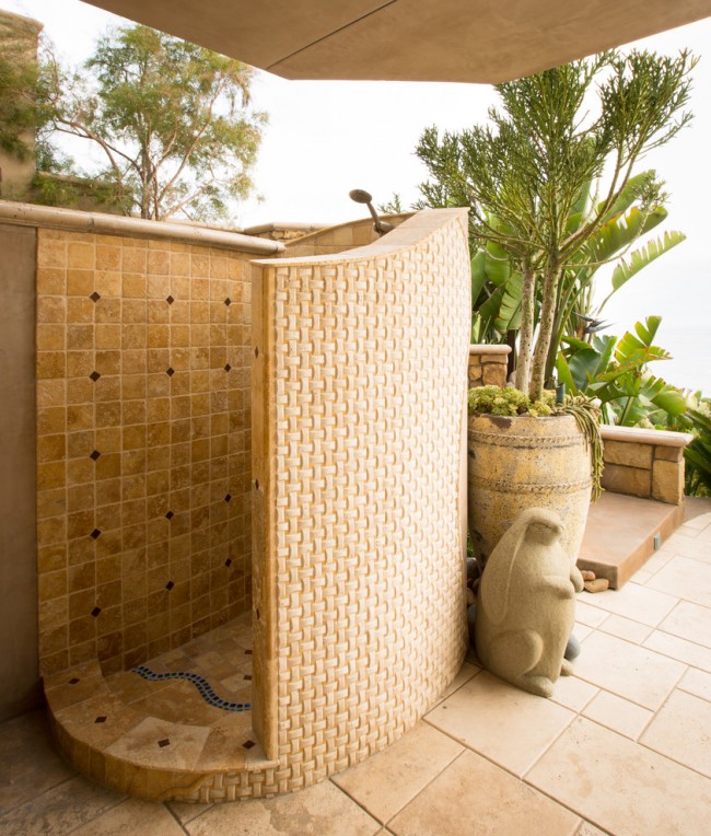 Une combinaison de matériaux naturels et synthétiques dans une douche de luxe près d'une maison de campagne de style méditerranéen