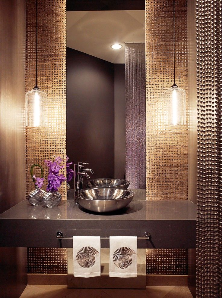 Les perles métalliques, faisant écho aux mêmes éléments intérieurs, ont fière allure dans une salle de bain moderne 