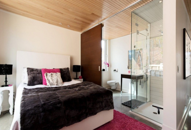 Intérieur de chambre à coucher moderne avec une cloison en verre dans la salle de bain