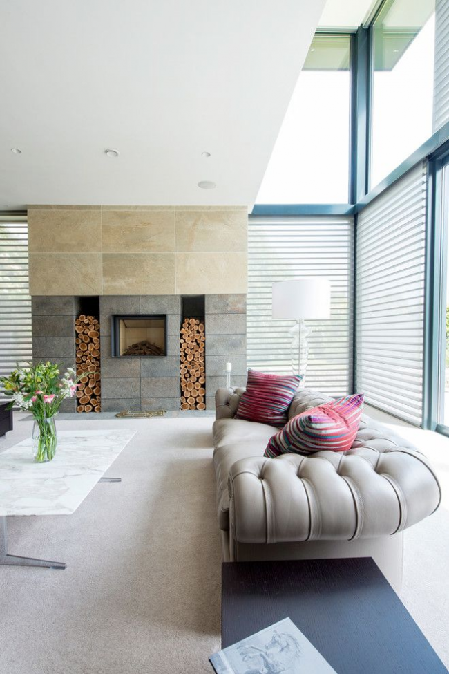 Intérieur spacieux du salon d'une maison privée avec un canapé Chesterfield gris dans un design moderne