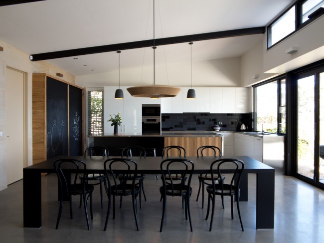 Cuisine moderne en bois noir et blanc dans une maison privée spacieuse construite conformément aux tendances architecturales pionnières
