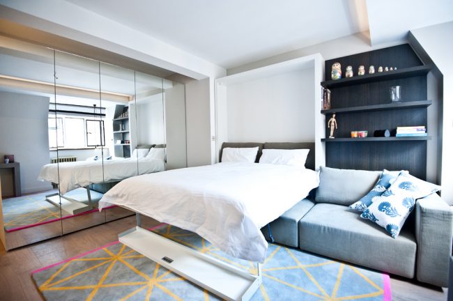 Même le design du lit transformable chambre à coucher, qui est caché dans le mur, économisera parfaitement de l'espace dans une petite chambre-salon d'une superficie de 18 m².  m peut être très confortable et beau