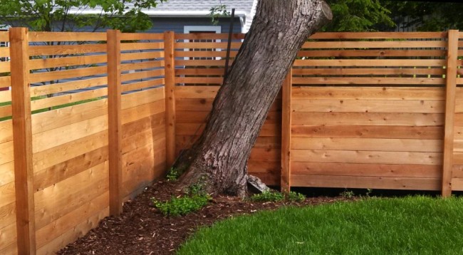 Clôtures en bois et clôtures pour la maison.  L'un des moyens les plus courants d'organiser l'espace privé de la cour: les planches de la partie inférieure de la clôture en bois sont étroitement ajustées les unes aux autres, les planches supérieures donnent une vue des deux côtés
