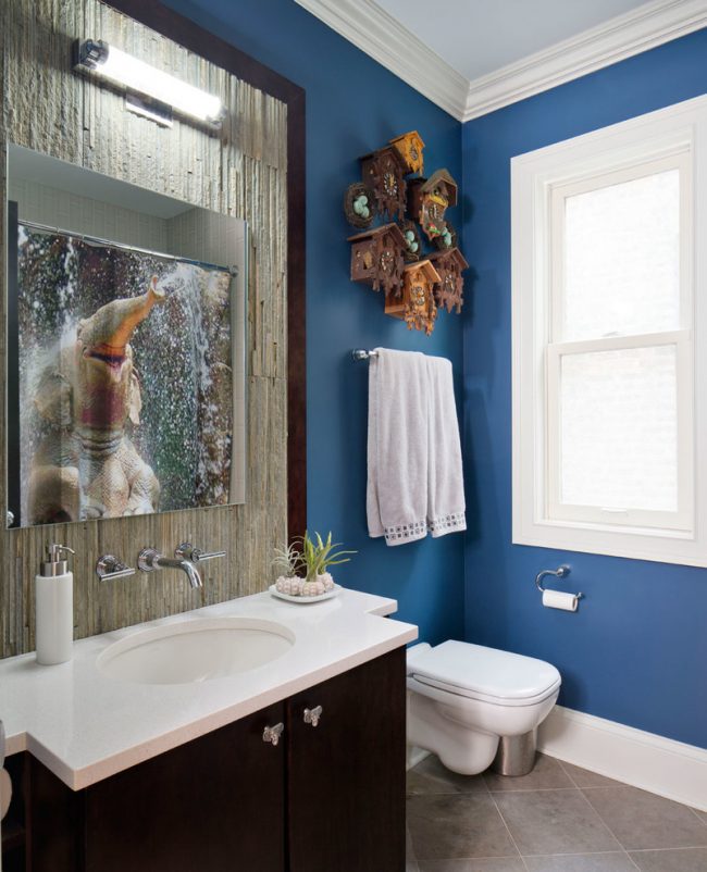 Une quantité équilibrée de bleu profond combinée à un mobilier en bois naturel dans une petite salle de bain