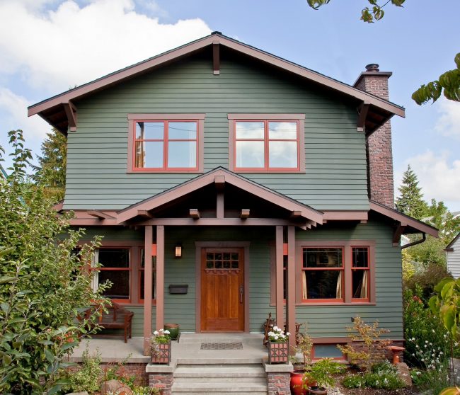Une belle combinaison de couleurs vertes et brunes dans la conception de la façade d'une maison à deux étages